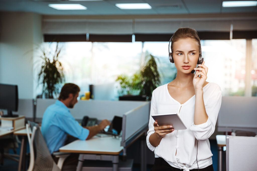 young beautiful female support phone operator speaking, consulting, over office background.